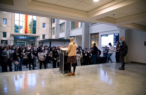 A woman standing at a podium in front of a crowd.