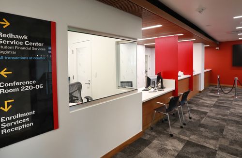 Redhawk Service Center reception area with service counters and a directional sign.